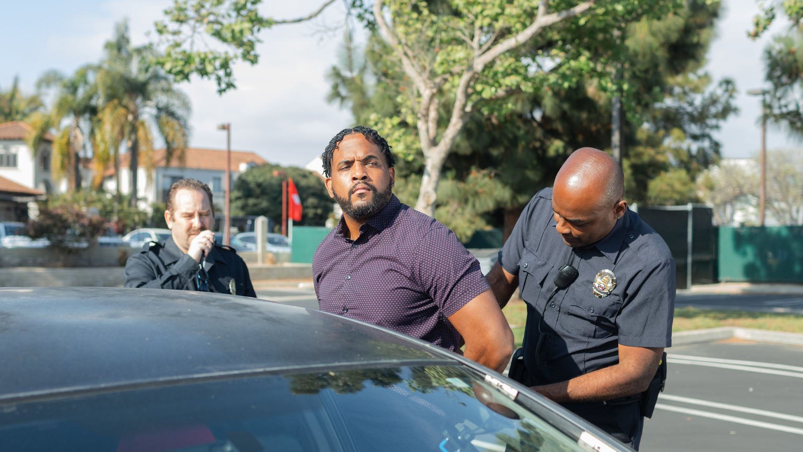 Two police officers working together to calmly handcuff a standing man