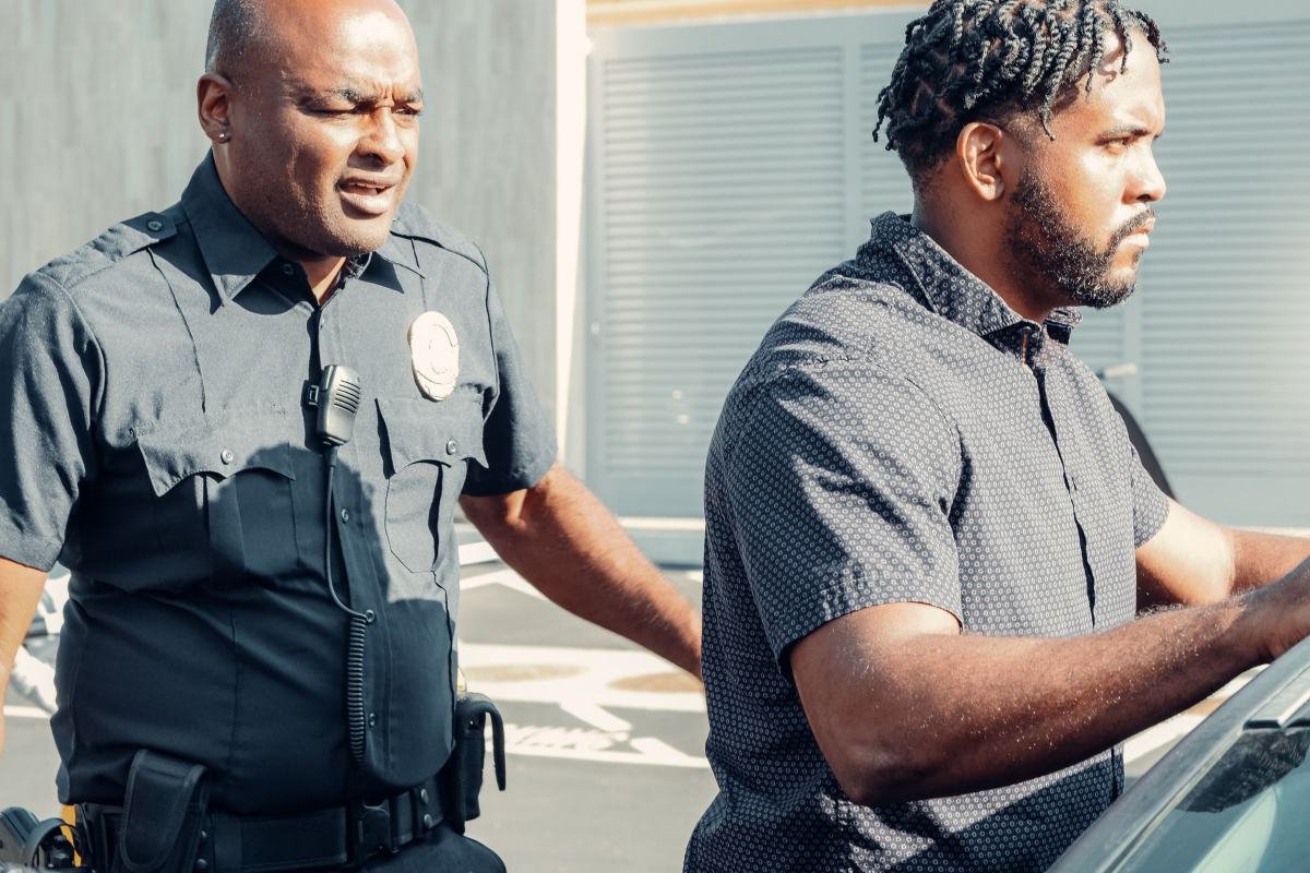 An officer calmly guiding a man to a vehicle during a handover