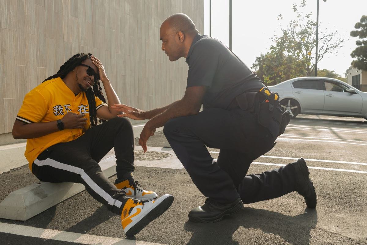 An officer kneeling at eye level to speak with a distressed man
