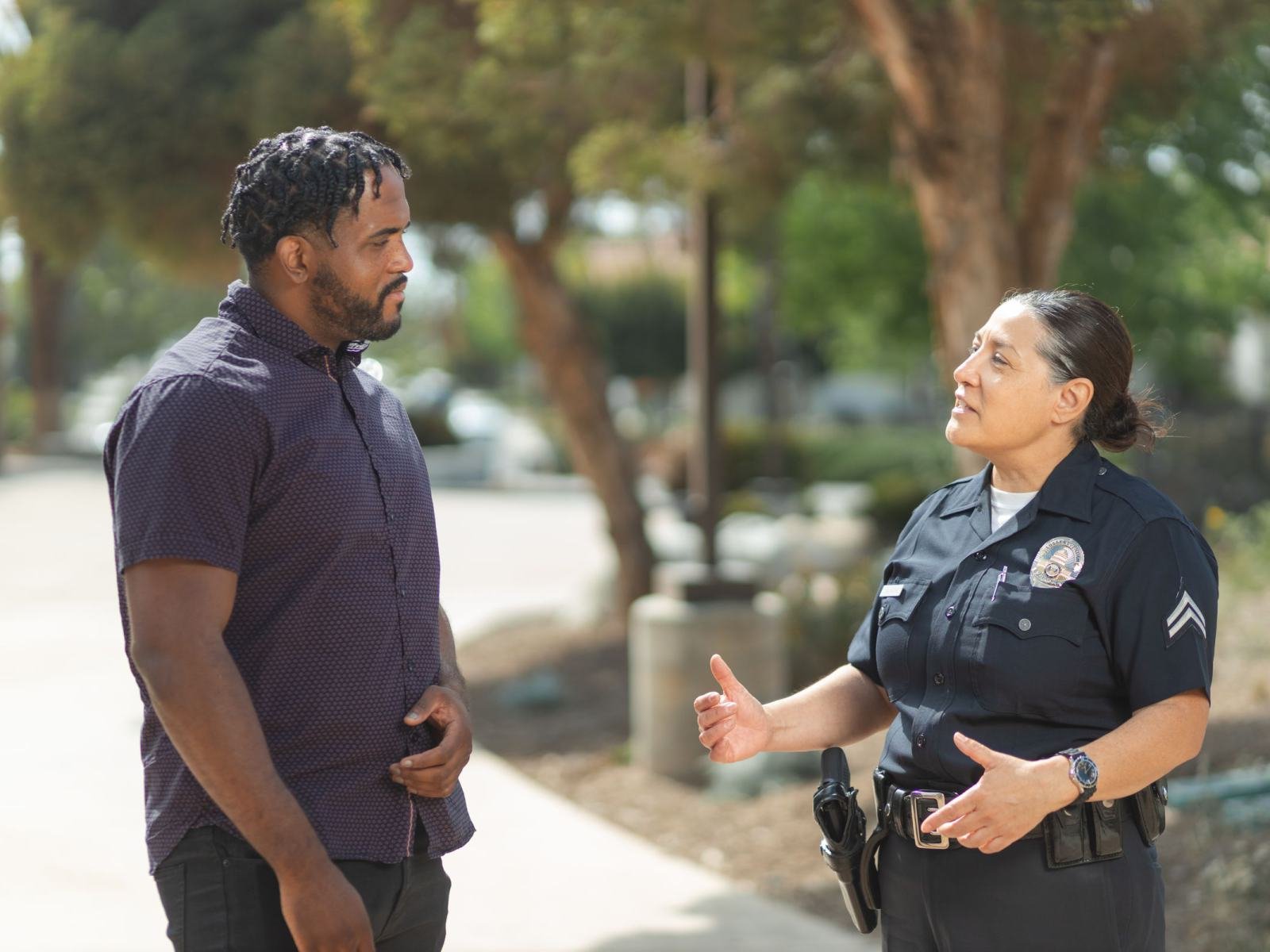 A police officer talking calmly with a man, using open hand gestures
