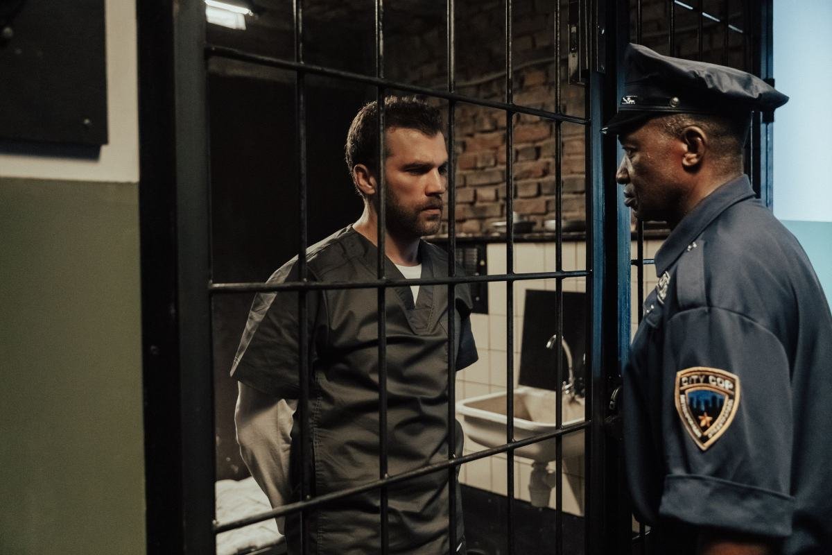 A correctional officer speaking calmly with a person in a cell