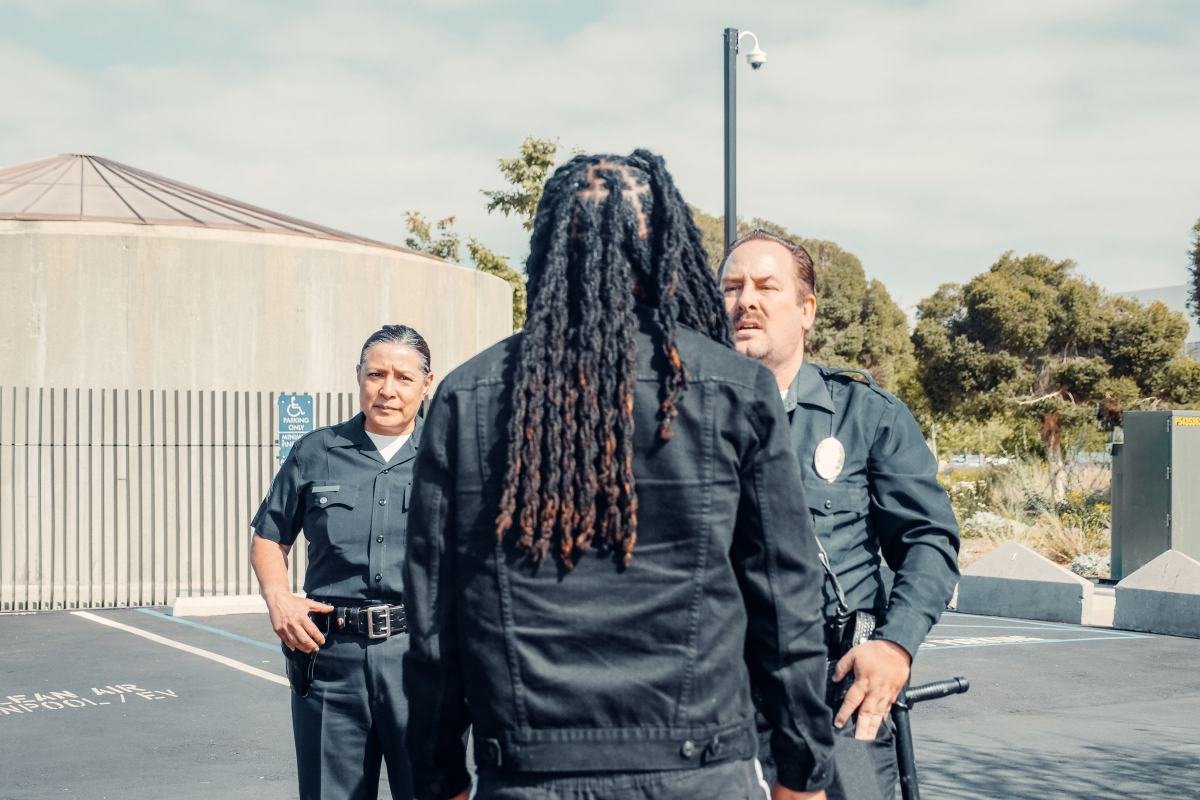 Two police officers keeping a safe distance while talking calmly with a man